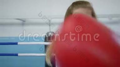 戴着手套的女拳击手准确地打出拳，看着戒指上的镜头